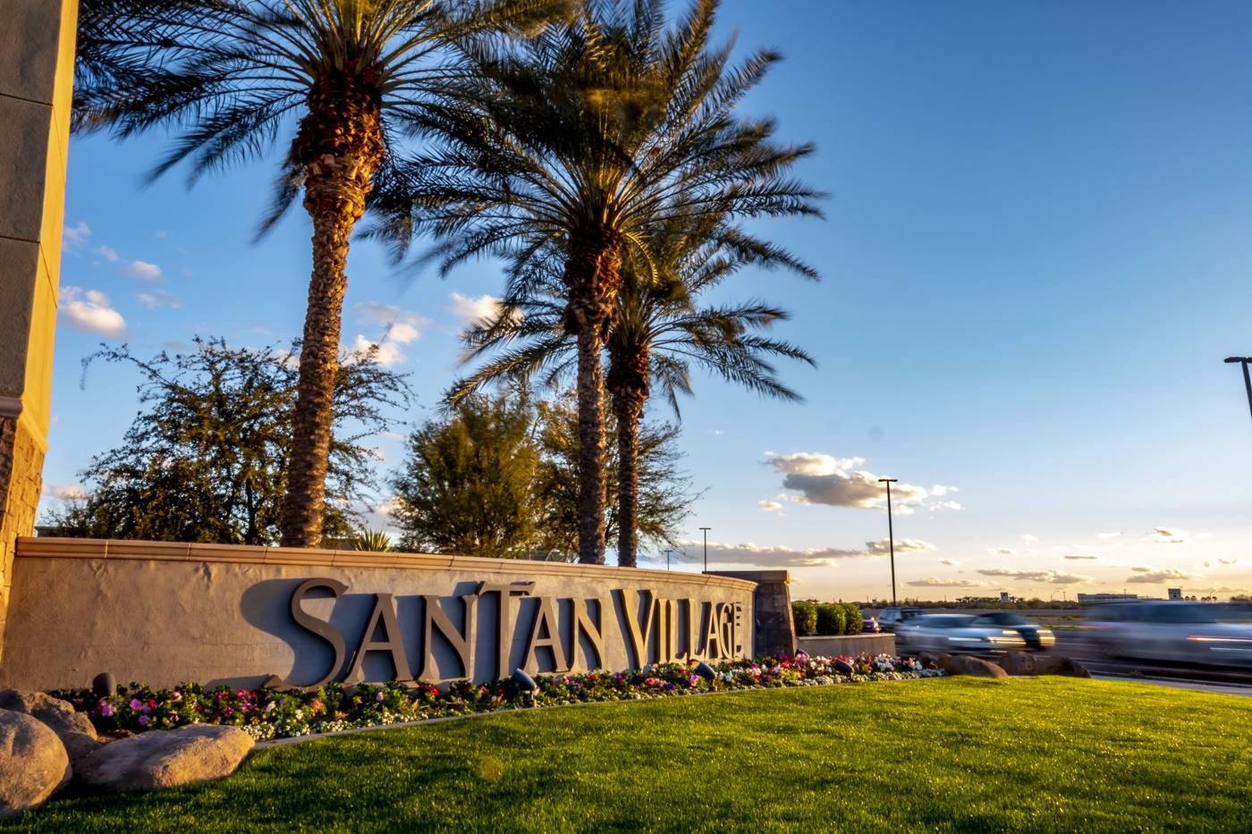 Monument sign with palm trees at sunset
