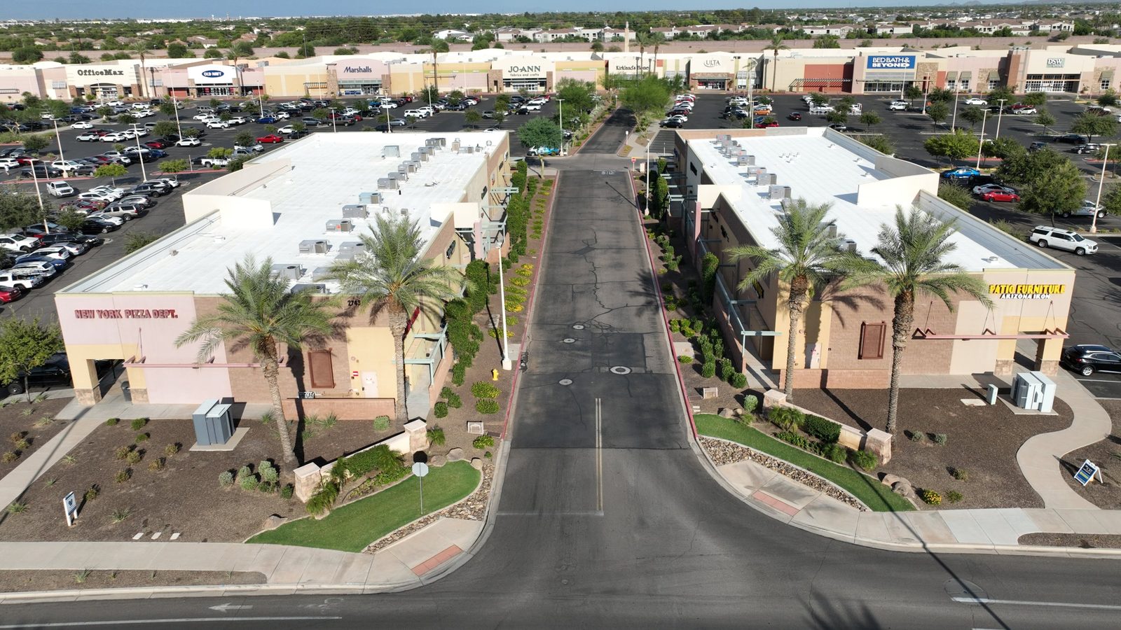 Entrance to SanTan Village Marketplace between NYPD Pizza and Arizona Iron Patio Furniture, with the main row of stores behind
